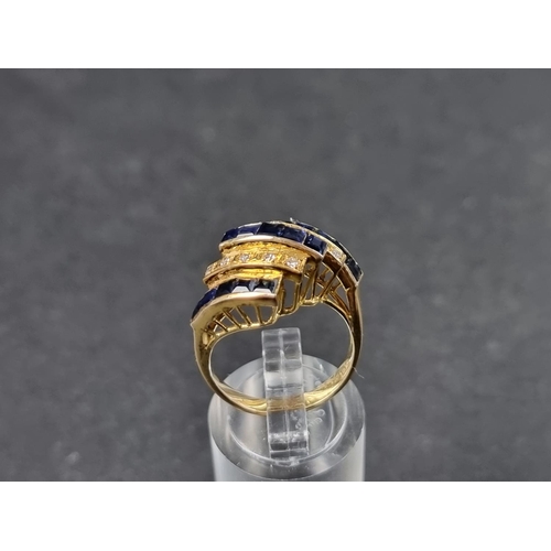 944 - A yellow metal ring, having five rows of pave set sapphires and diamonds, stamped '18k', size N.... 