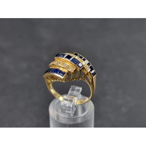 944 - A yellow metal ring, having five rows of pave set sapphires and diamonds, stamped '18k', size N.... 