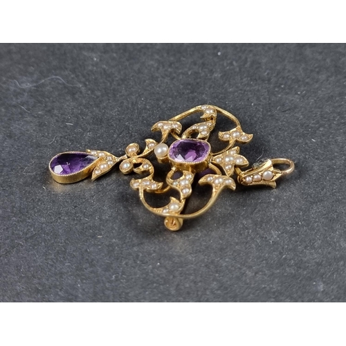 947 - An Edwardian yellow metal pendant/brooch, set two amethysts and seed pearls, 56mm high x 33mm wide.... 