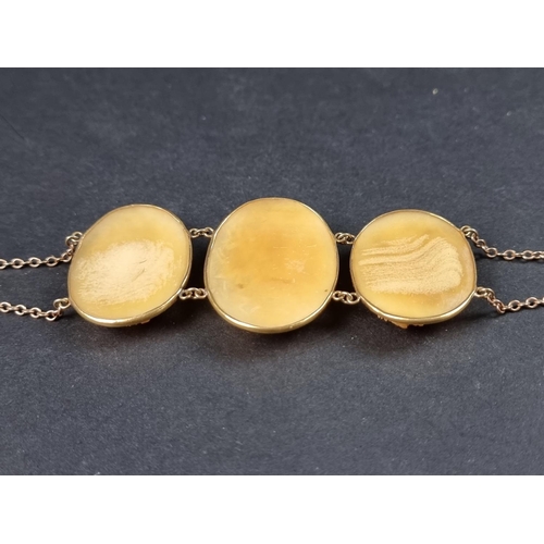 952 - A late 19th century bracelet, set three carved horn floral panels, in a yellow metal setting, stampe... 