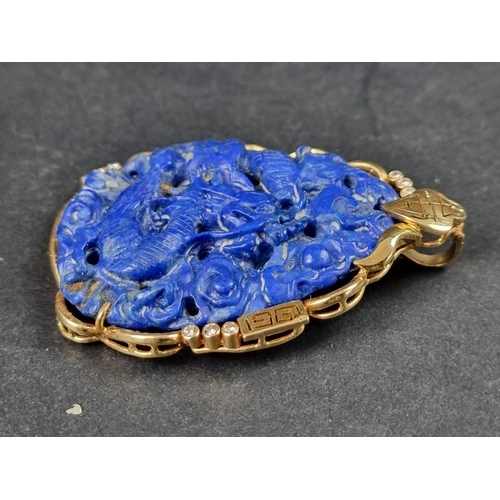 956 - A Chinese carved lapis lazuli pendant, decorated Dragon to front and Phoenix to reverse, in a yellow... 