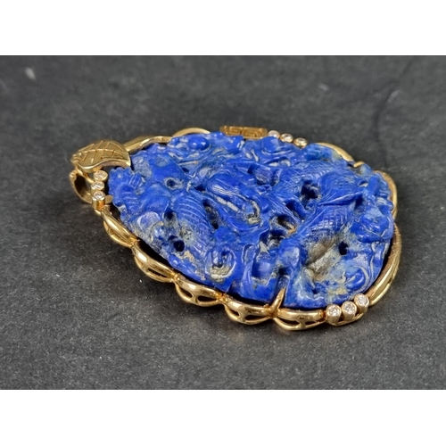 956 - A Chinese carved lapis lazuli pendant, decorated Dragon to front and Phoenix to reverse, in a yellow... 