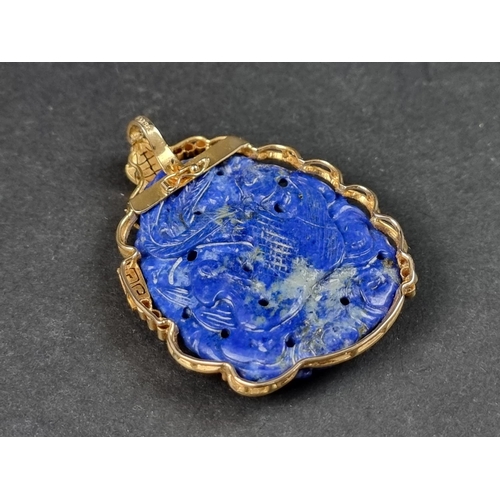 956 - A Chinese carved lapis lazuli pendant, decorated Dragon to front and Phoenix to reverse, in a yellow... 