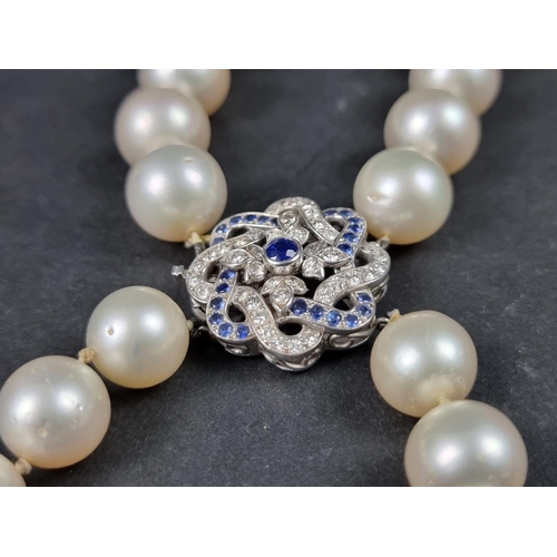 959 - A South Sea freshwater pearl necklace, having precious metal diamond and sapphire set floral knot cl... 