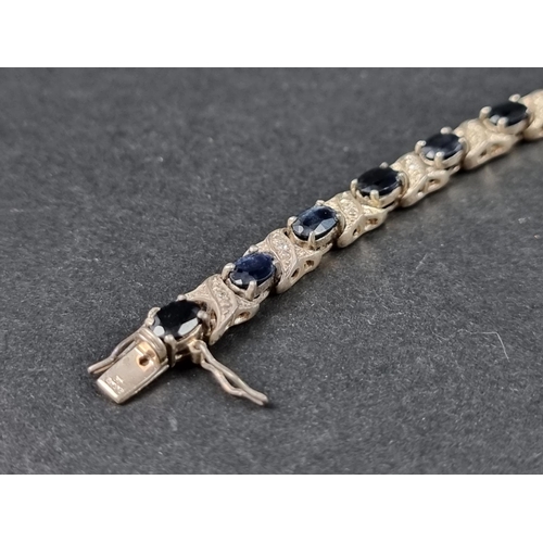 961 - A silver bracelet, set sixteen faceted sapphires and sixteen small diamonds, import mark Birmingham ... 