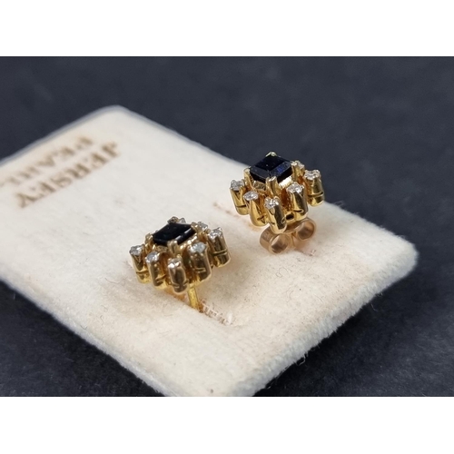 970 - A pair of yellow metal ear studs, set central sapphire surrounded by eight small brilliant cut diamo... 