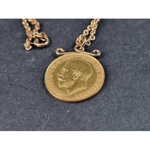 975 - A George V 1914 gold half sovereign, in pendant mount, on a yellow metal chain stamped '15ct', gross... 