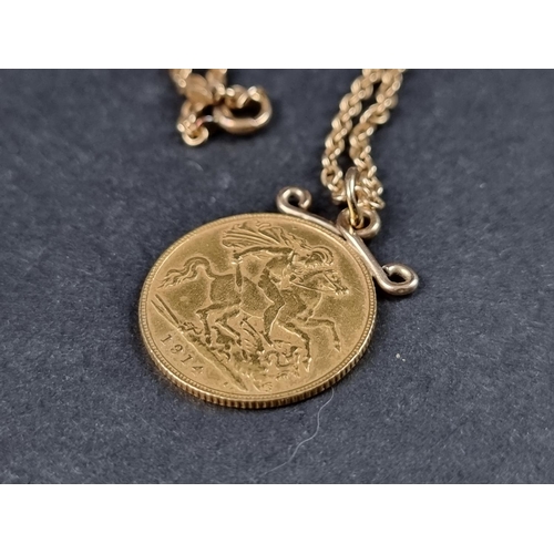 975 - A George V 1914 gold half sovereign, in pendant mount, on a yellow metal chain stamped '15ct', gross... 