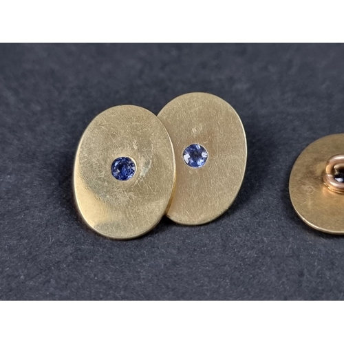 979 - A pair of yellow metal cufflinks, each set sapphire, stamped 15, 17mm.