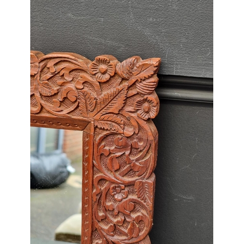 1001 - A Thai carved hardwood framed wall mirror, 42 x 50cm. 