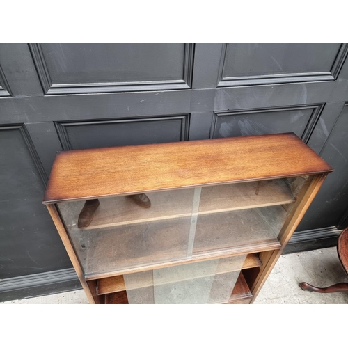 1012 - A mahogany bookcase, with glass sliding doors, 91.5cm wide, labelled Herbert E Gibbs.... 