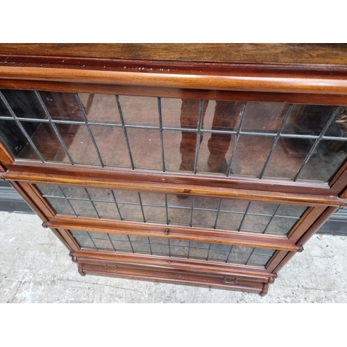 1038 - An early 20th century Globe Wernicke mahogany four tier sectional bookcase, with leaded glass panels... 