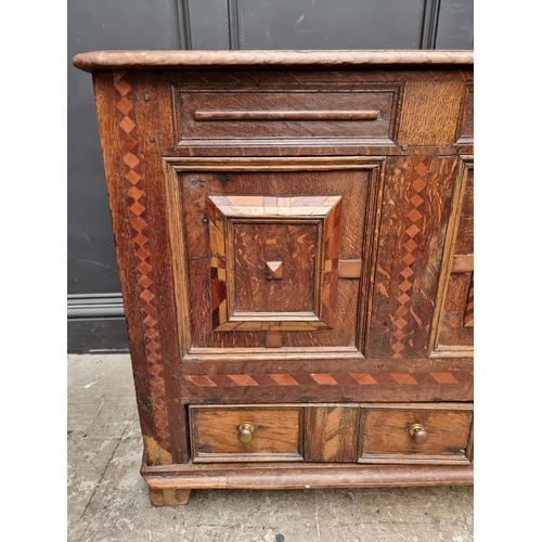 1051 - A late 17th century panelled oak and parquetry mule chest, 129.5cm wide. 