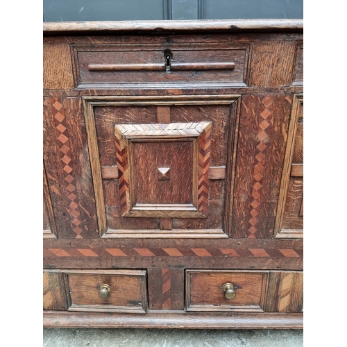 1051 - A late 17th century panelled oak and parquetry mule chest, 129.5cm wide. 