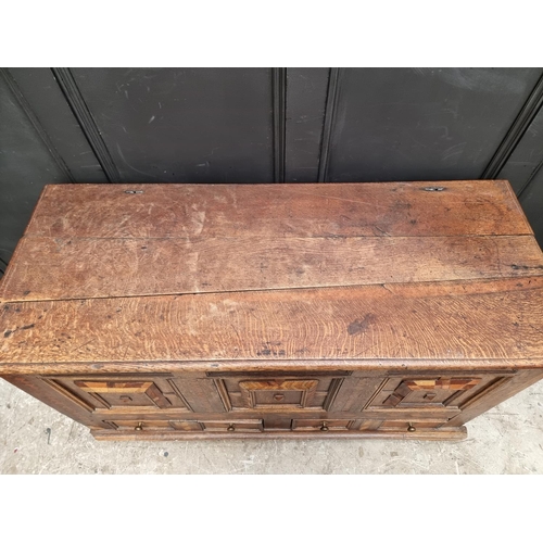 1051 - A late 17th century panelled oak and parquetry mule chest, 129.5cm wide. 