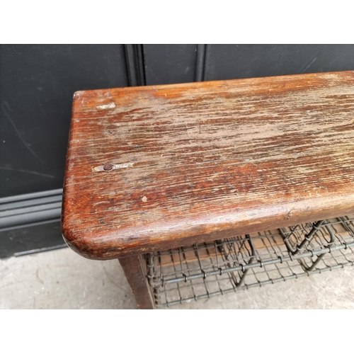 1090 - A vintage stained pine combined bench and shoe rack, 128cm wide.