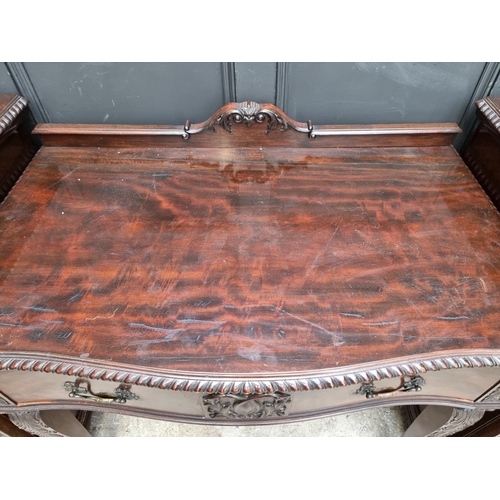 1091 - An early 20th century carved mahogany serpentine fronted sideboard and matching pedestals, 107cm wid... 