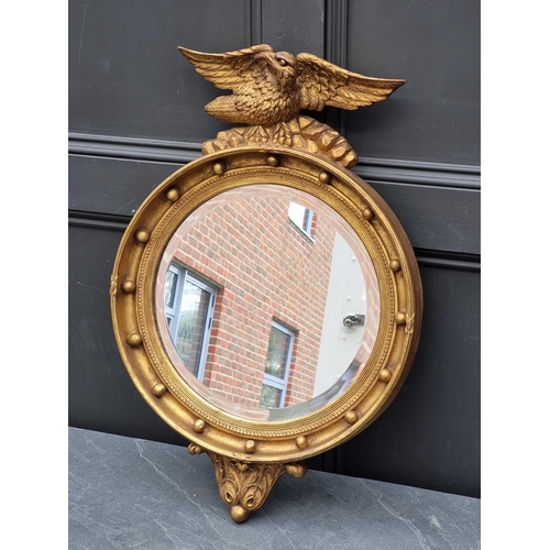 1116 - WITHDRAWN: A reproduction gilt framed circular wall mirror, 69.5 x 46cm.