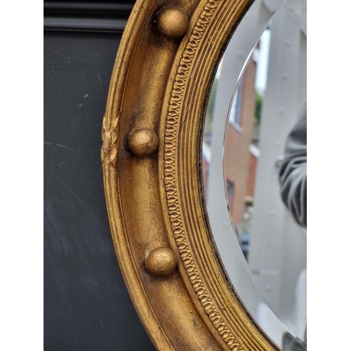 1116 - WITHDRAWN: A reproduction gilt framed circular wall mirror, 69.5 x 46cm.