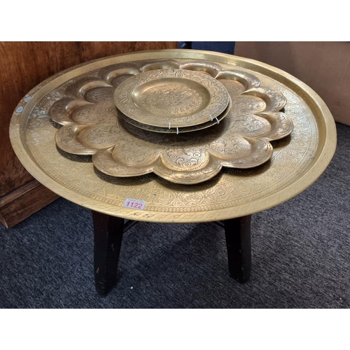 1122 - An Islamic brass tray, 64cm diameter, on associated hardwood stand; together with another India... 