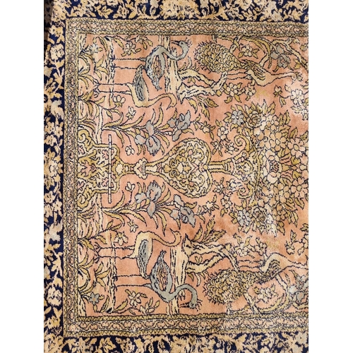 1141 - A Kashmiri rug, central field decorated urn and flowers, with storks, trees and birds, 227 x 170cm.... 