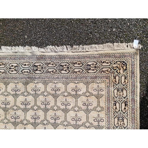 1145 - A Kashmiri rug, having repeated decoration to central field, geometric borders on a cream and black ... 