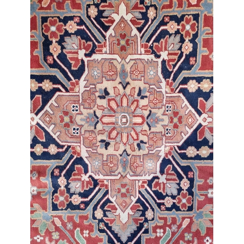 1147 - A large carpet, having central star medallion, with floral cartouches to each corner, with floral bo... 