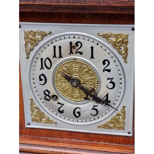 1266 - An old stained oak mantel clock, 33cm high, with pendulum.