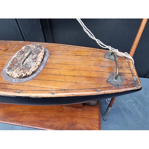 1417 - A vintage pond yacht, the hull 66cm long, on mahogany stand.