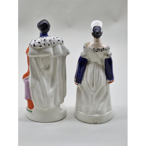 1541 - A pair of Victorian Staffordshire pottery figures of 'Queen Victoria' and 'Prince Albert', 28cm high... 