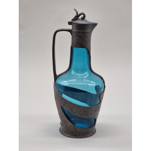 1550 - A Continental Art Nouveau pewter and blue glass claret jug, 29cm high.