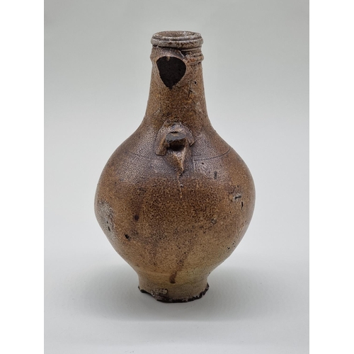 1574 - A salt glazed Bellarmine jug, probably 17th century, 23cm high, (a.f.).