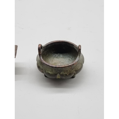 1631 - A miniature Chinese bronze twin handled tripod censer, seal mark to base, 5cm wide; together with a ... 