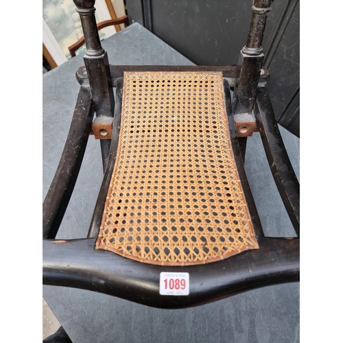 1089 - A Victorian ebonized and cane folding campaign style chair. 