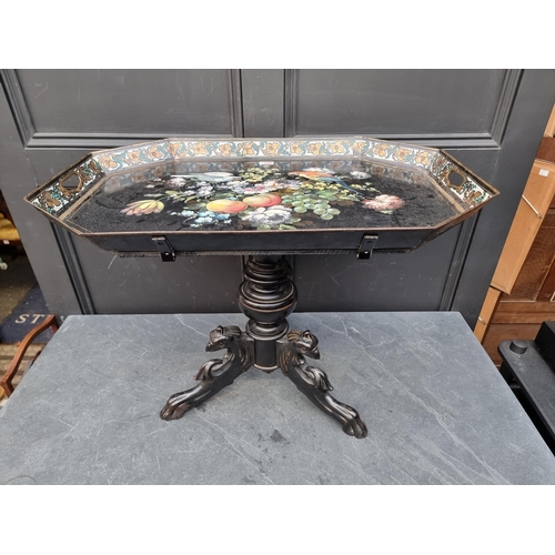 1096 - A 19th century toleware tray, 70cm wide; on associated ebonized tripod stand.