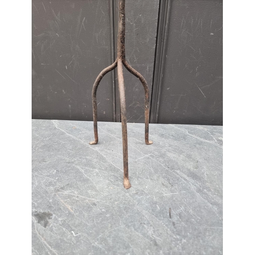 1532 - An antique wrought iron tripod candle stick, 85cm high.