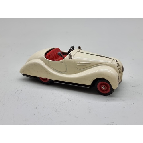 1830 - Schuco: a vintage (1950s) cream Examico 4001 clockwork car, (no key, base partially detached).... 