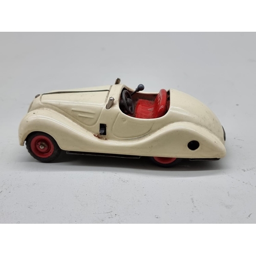 1830 - Schuco: a vintage (1950s) cream Examico 4001 clockwork car, (no key, base partially detached).... 