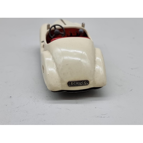 1830 - Schuco: a vintage (1950s) cream Examico 4001 clockwork car, (no key, base partially detached).... 