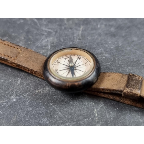 203 - A vintage wrist compass, 25mm, with leather strap.