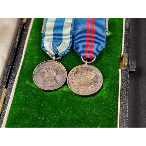 214 - A Victoria 1897 Jubilee Medal; together with a 1911 George V Coronation Medal, cased; and a matching... 