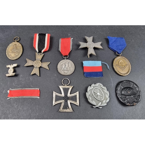 220 - A WWII German Iron cross; together with seven other German WWII medals and badges.