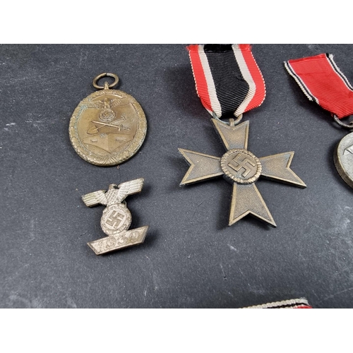 220 - A WWII German Iron cross; together with seven other German WWII medals and badges.