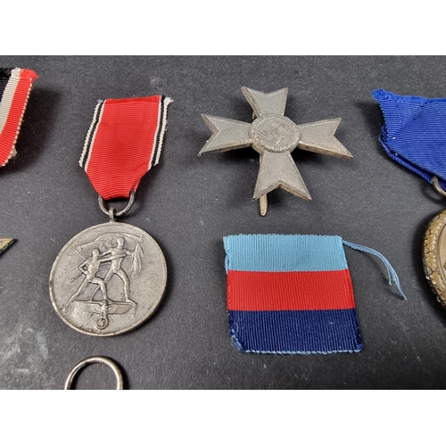 220 - A WWII German Iron cross; together with seven other German WWII medals and badges.