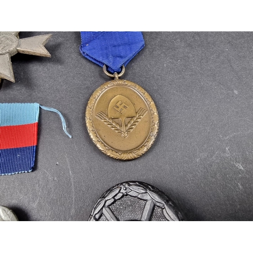 220 - A WWII German Iron cross; together with seven other German WWII medals and badges.