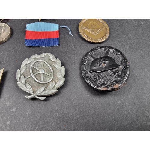 220 - A WWII German Iron cross; together with seven other German WWII medals and badges.