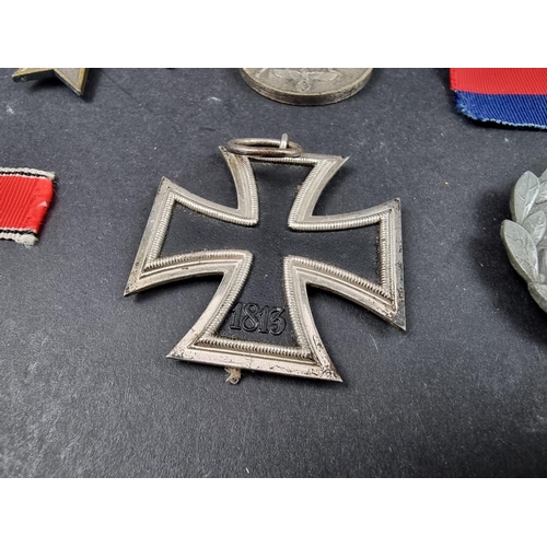 220 - A WWII German Iron cross; together with seven other German WWII medals and badges.