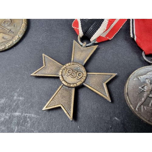 220 - A WWII German Iron cross; together with seven other German WWII medals and badges.