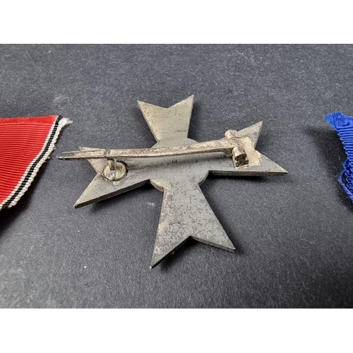 220 - A WWII German Iron cross; together with seven other German WWII medals and badges.