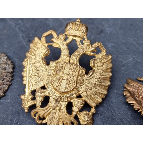 239 - A Prussian gilt metal pickelhaube helmet front badge, 9cm high; together with various other military... 